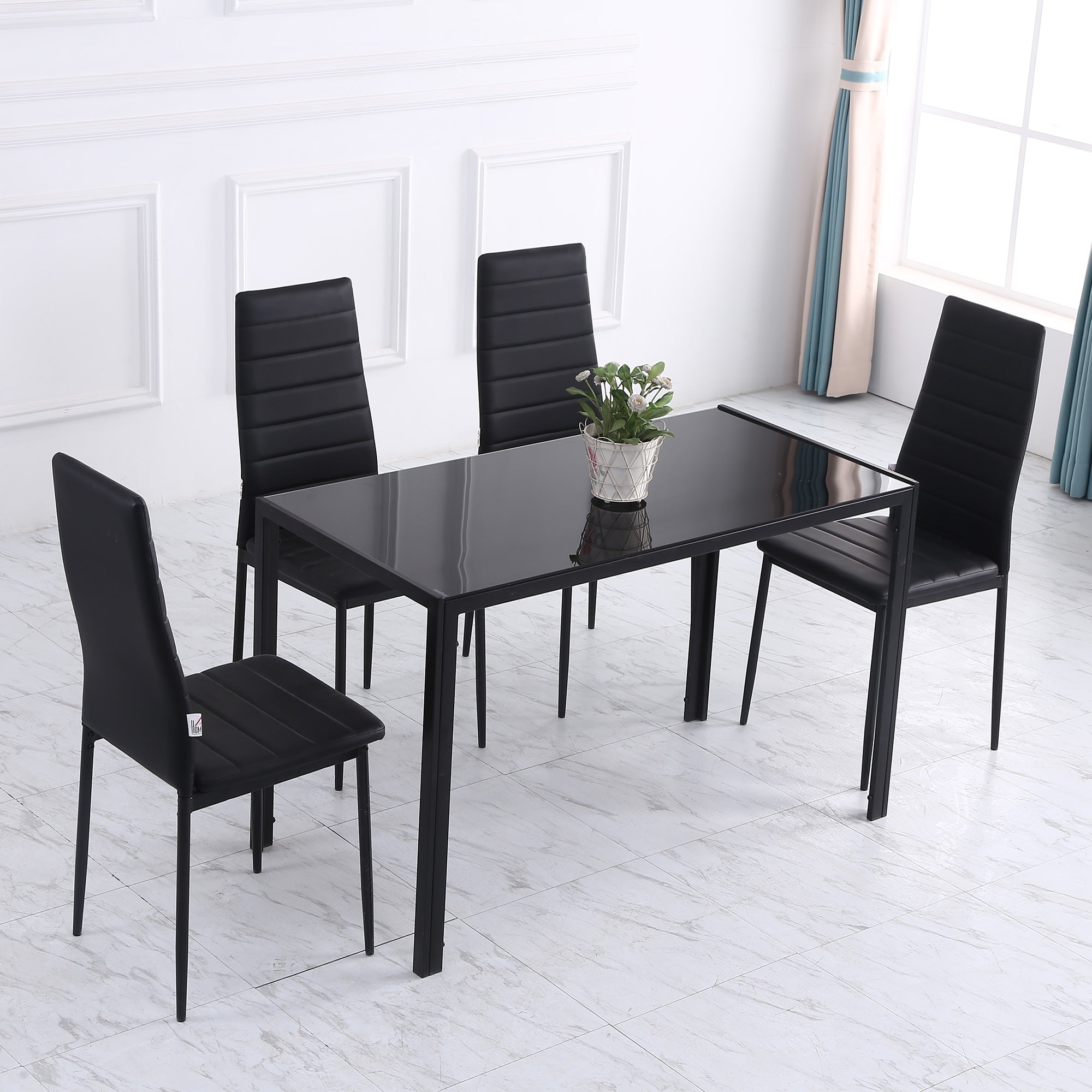 Black tempered glass dining table with metal legs and four matching black upholstered chairs for dinner parties