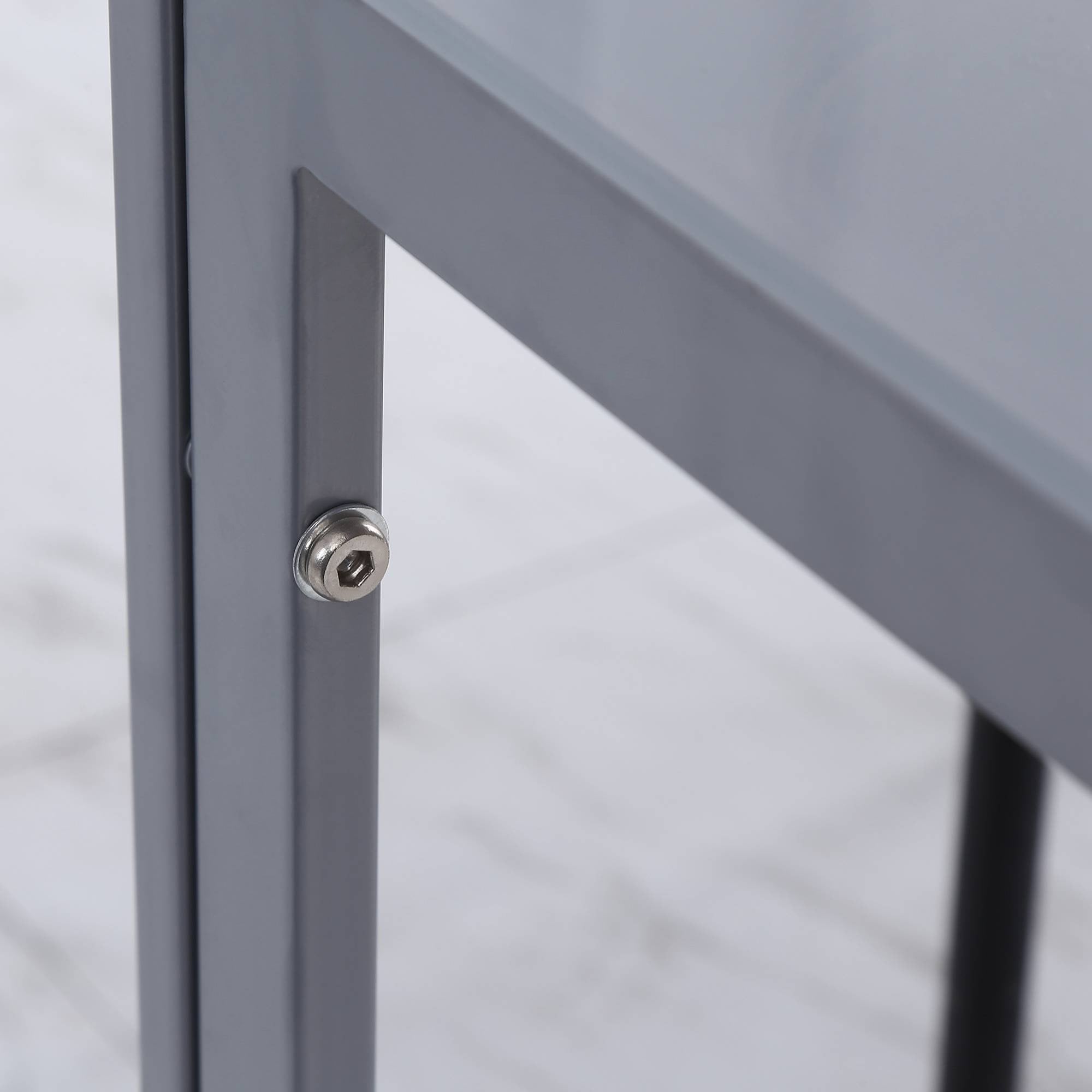 Silver hexagonal head screw securing gray powder coated steel frame of homcom modern dining table with tempered glass top