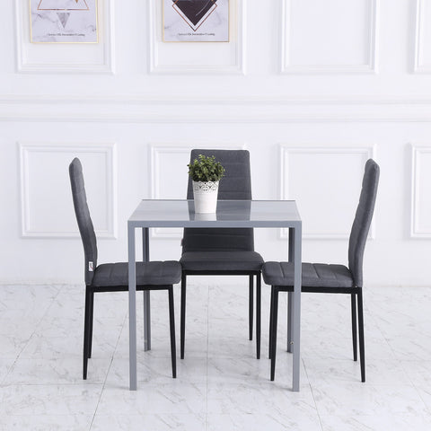 Modern gray dining table with tempered glass top and powder coated steel legs with three matching chairs