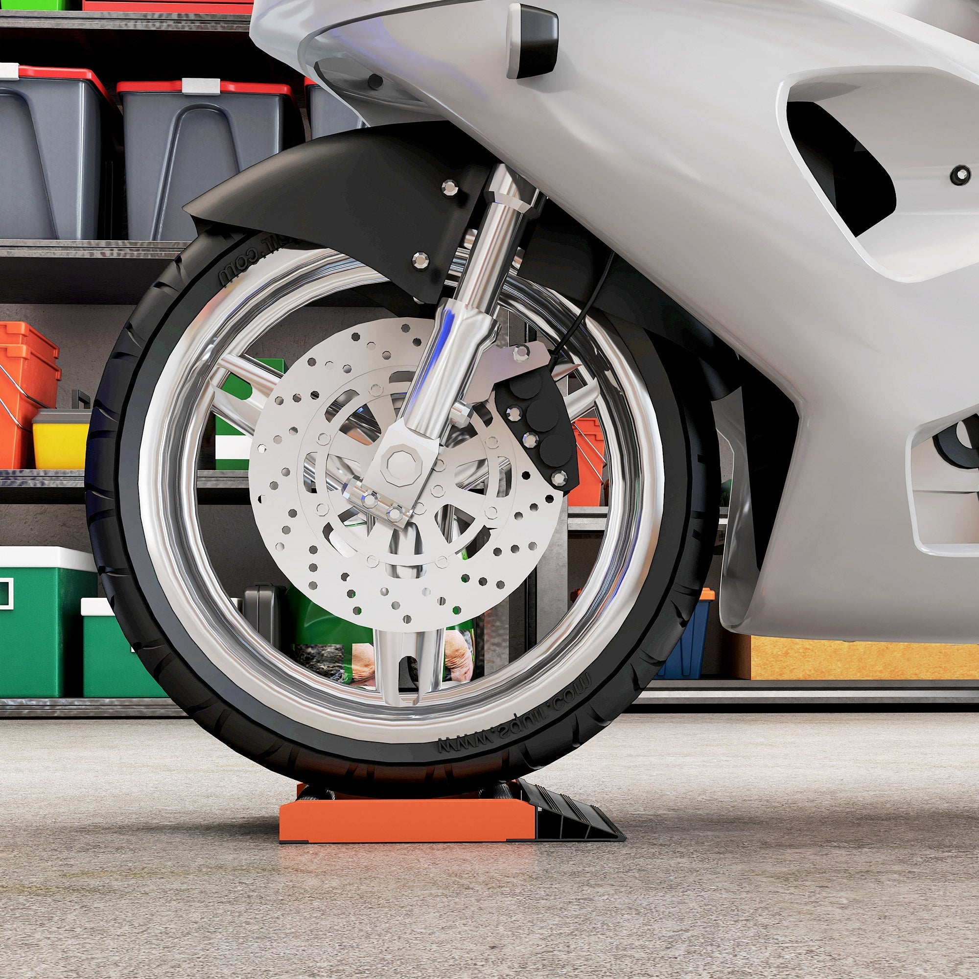 Orange plastic wheel chock under motorcycle wheel on aluminium alloy frame stand for tyre cleaning and chain lubrication