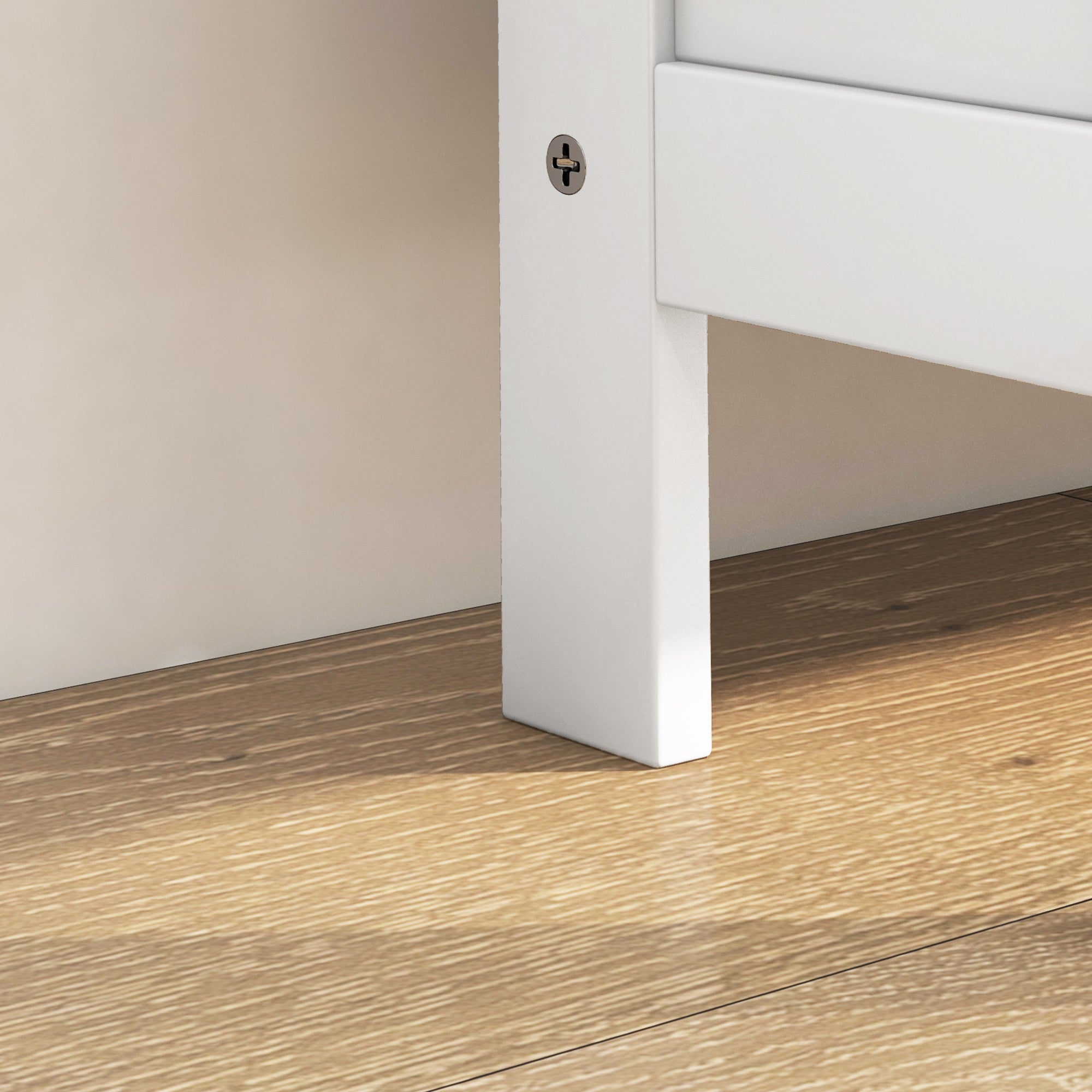 White painted wooden leg with metallic screw head on homcom narrow shoe storage cabinet with 3 flip drawers