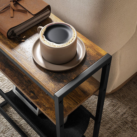 Beige ceramic coffee cup with dark brew on matching saucer next to rustic brown homcom narrow side table with steel frame and upper shelf
