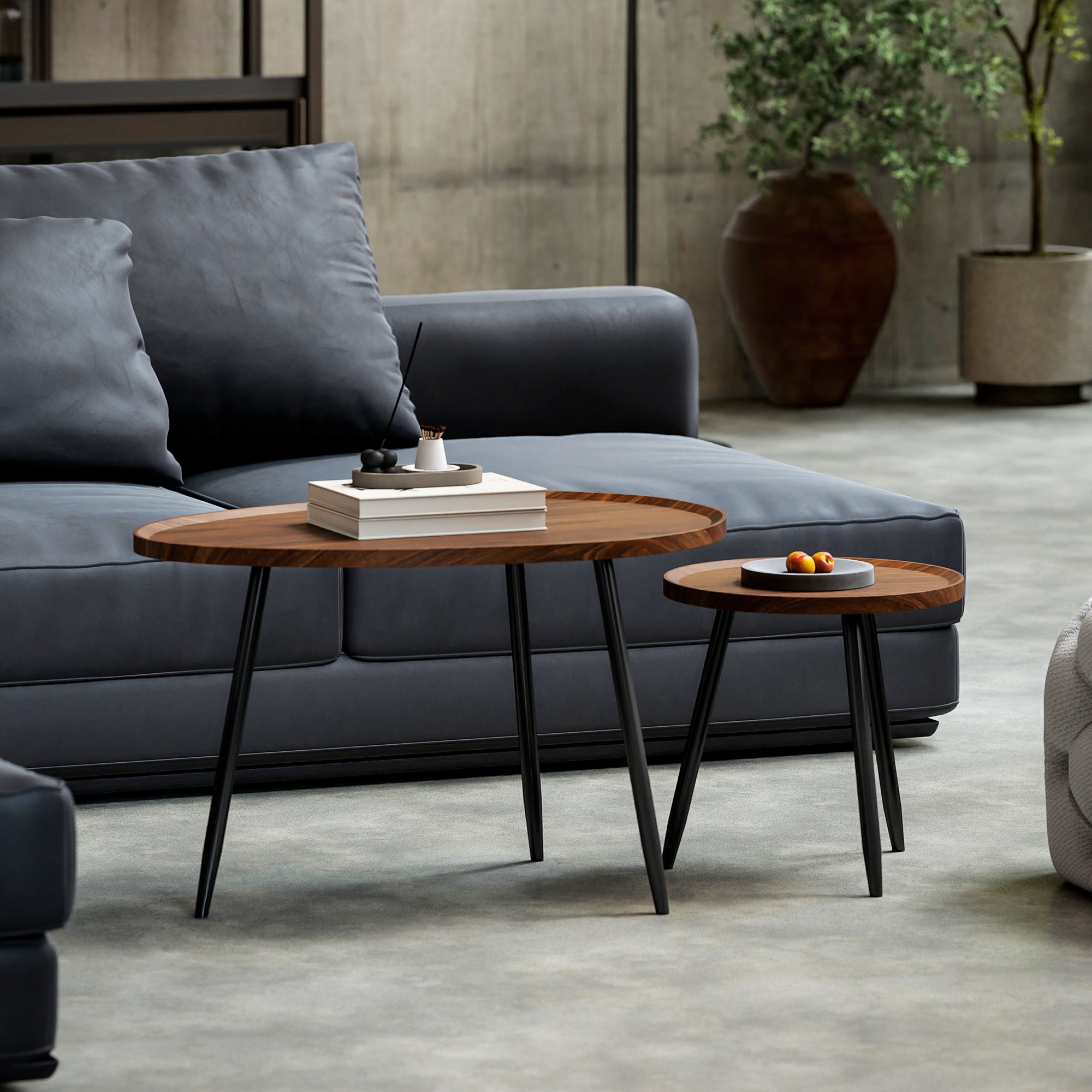 Two oval coffee tables with chestnut wood effect tops and sleek matte black metal legs for living room use