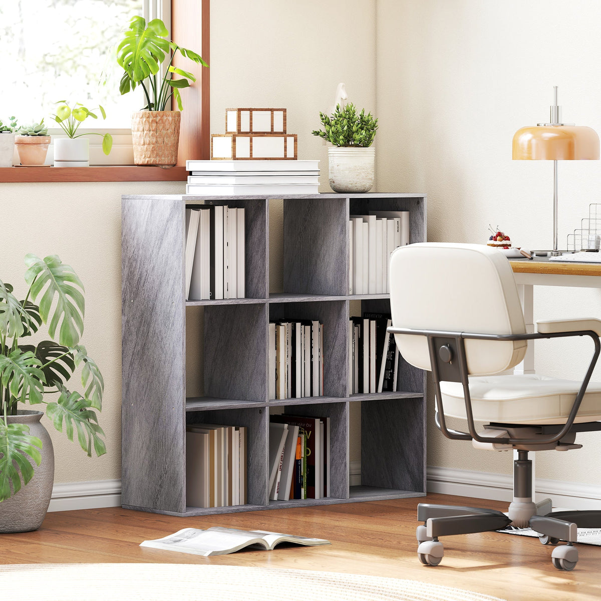 Gray wood-grain particle board bookshelf with nine open cubbies in marble grey featuring stacked books and decorative boxes