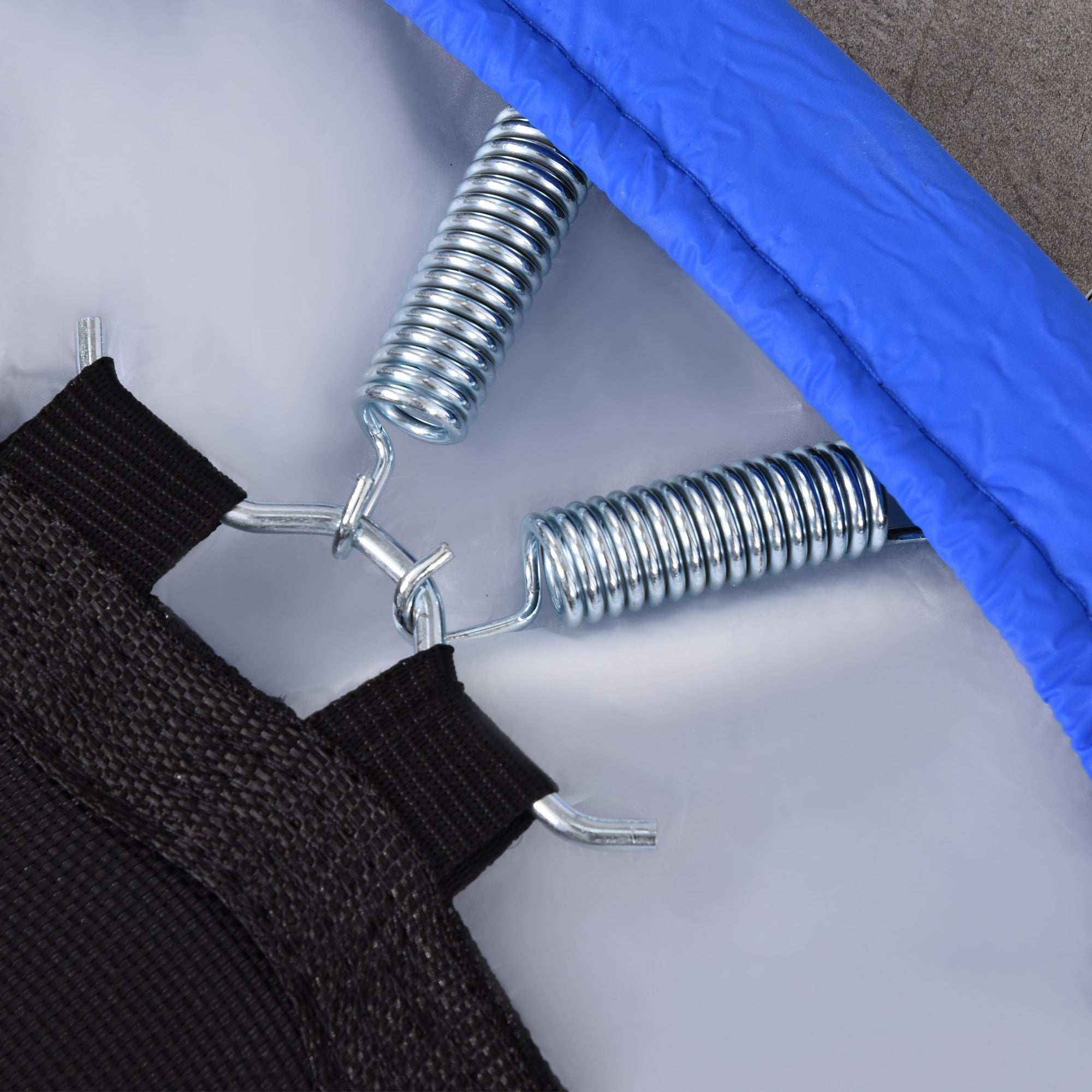 Silver metal springs attached to black straps on the blue and black homcom mini fitness trampoline metal frame safety pad