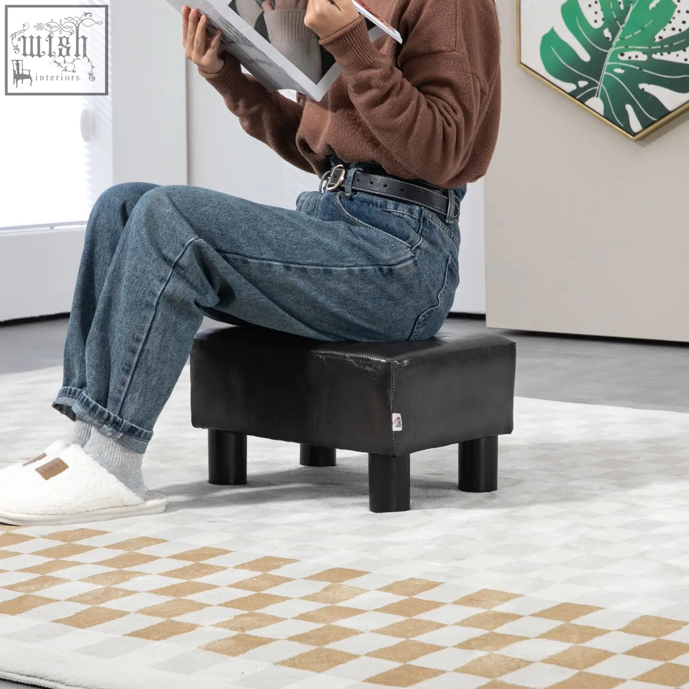 Black faux leather foot stool with plastic legs and wooden frame perfect for living room use