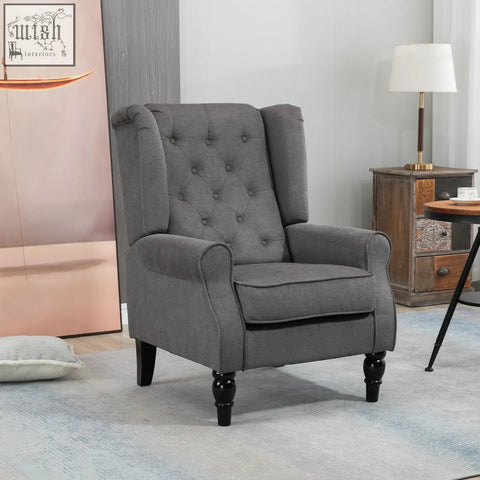 Gray tufted wingback accent chair with dark grey fabric and black wooden legs at floor height for living room use