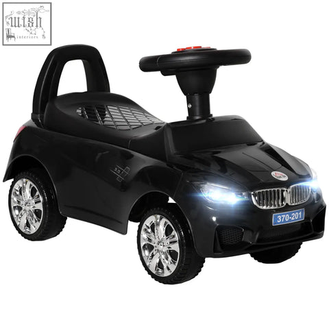 Black plastic homcom ride on car for toddlers with steering wheel, high backrest, chrome rims, and under-seat storage