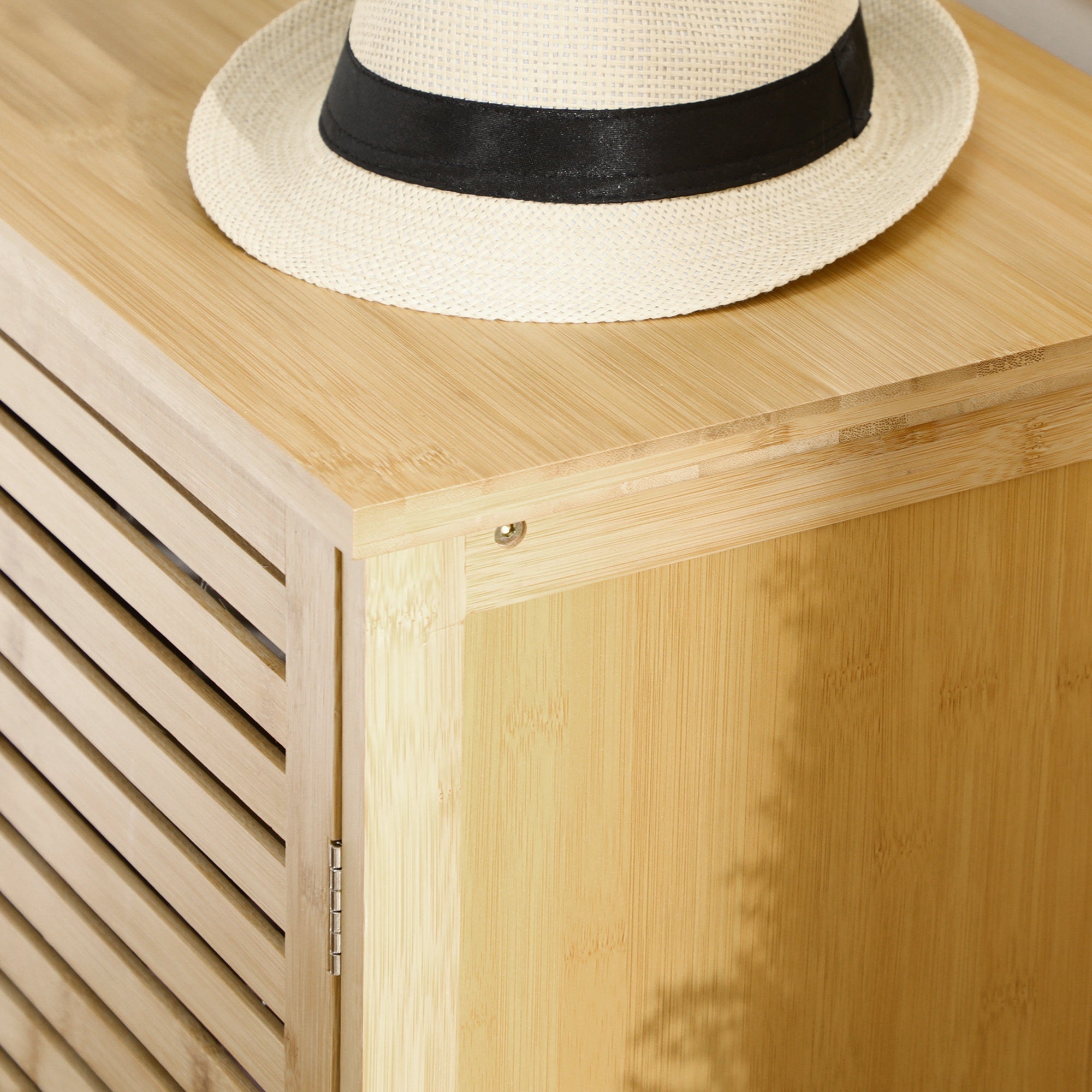 Cream-colored straw fedora hat with black ribbon displayed on homcom rustic shoe storage cabinet in natural wood finish