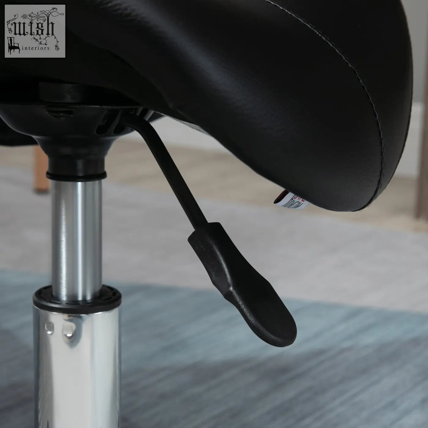 Black HOMCOM saddle stool with padded seat, steel frame, and chrome base for massage, spa, beauty, and tattoo use