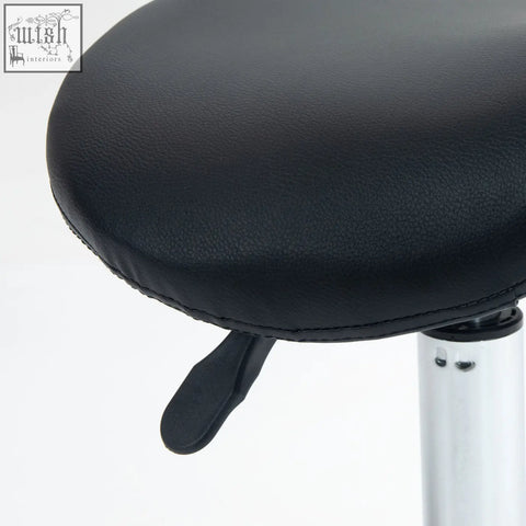 Black leatherette ergonomic saddle stool with silver metal base and height lever for salon and clinic use