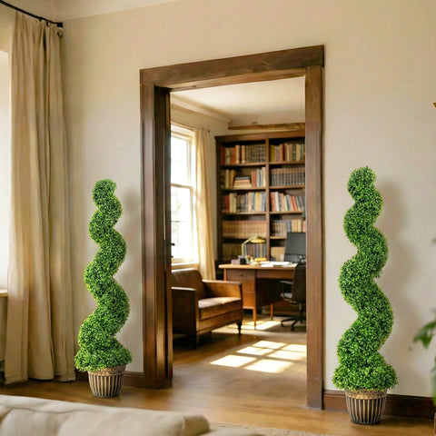 Two tall green spiral boxwood trees in striped ceramic pots flank a wooden doorway for indoor outdoor decor