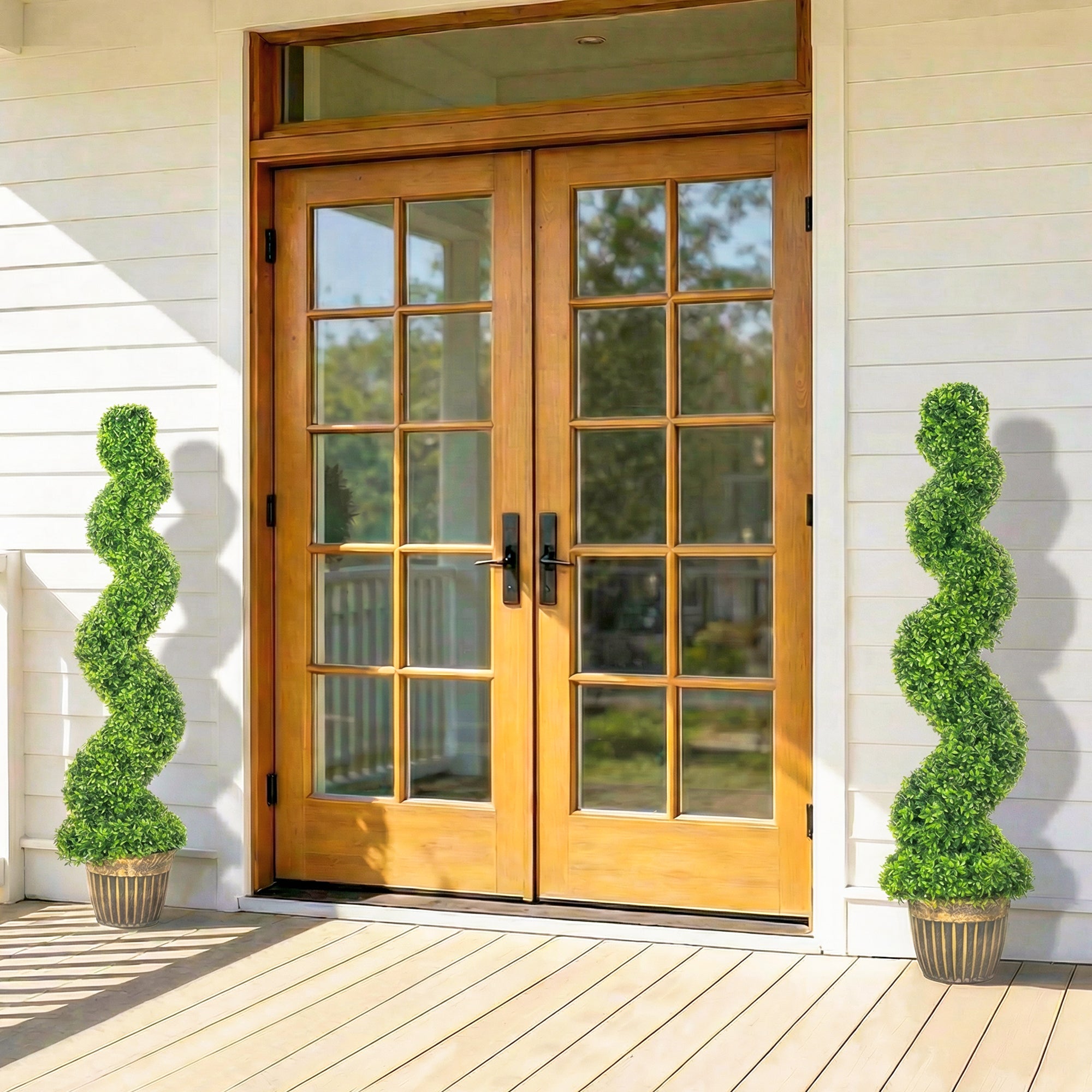 Pair of light oak french doors with glass panes and black hardware beside homcom spiral boxwood trees in pots