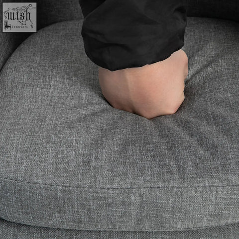 Gray linen upholstery cushion with hand pressing into it on homcom bar stools with solid wood legs and metal frame
