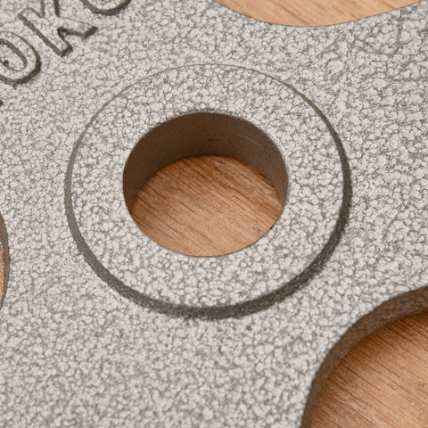 Gray speckled cast iron weight plates with centre hole and embossed lettering for 2 inch dumbbell handle bar