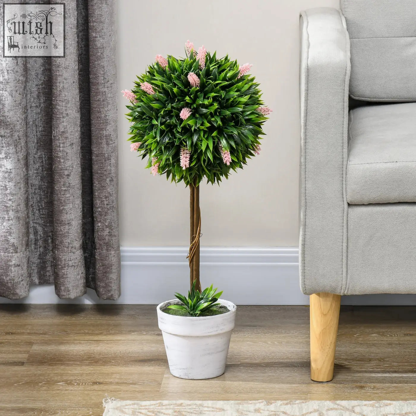 A low maintenance pink ball-shape tree with delicate lavender flowers in a white ceramic pot for indoor outdoor decor