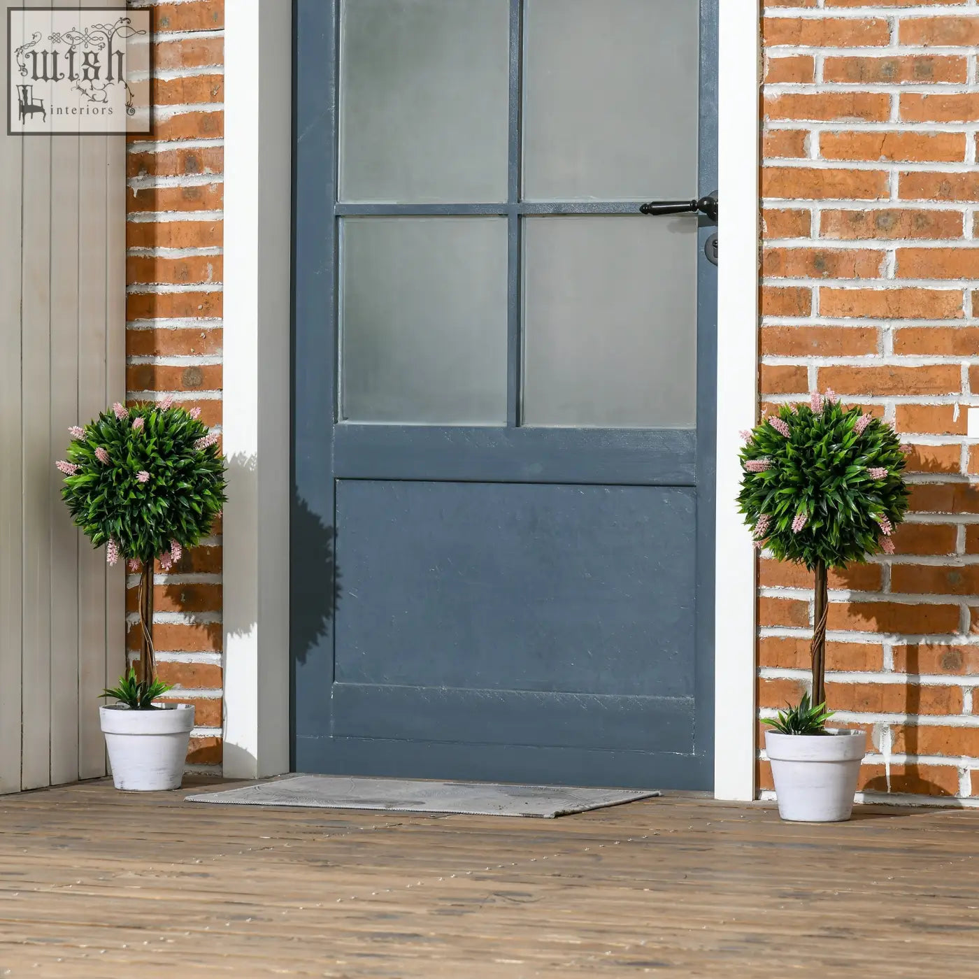 Two low maintenance pink ball-shape tree topiaries with lavender flowers in white ceramic pots for indoor outdoor decor