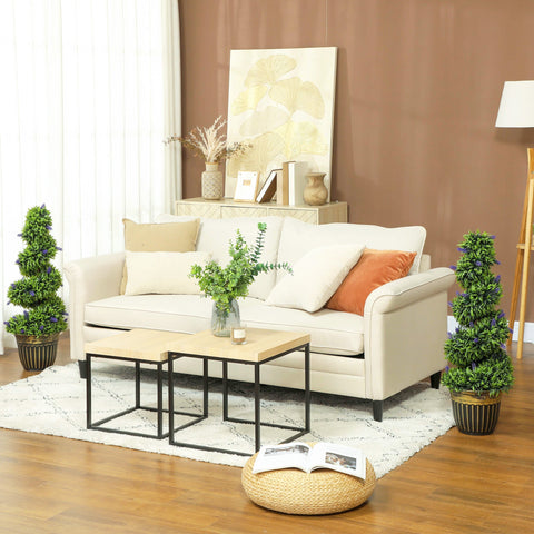 Cream-colored leather sofa with beige and orange throw pillows next to homcom decorative artificial plants with vibrant green leaves