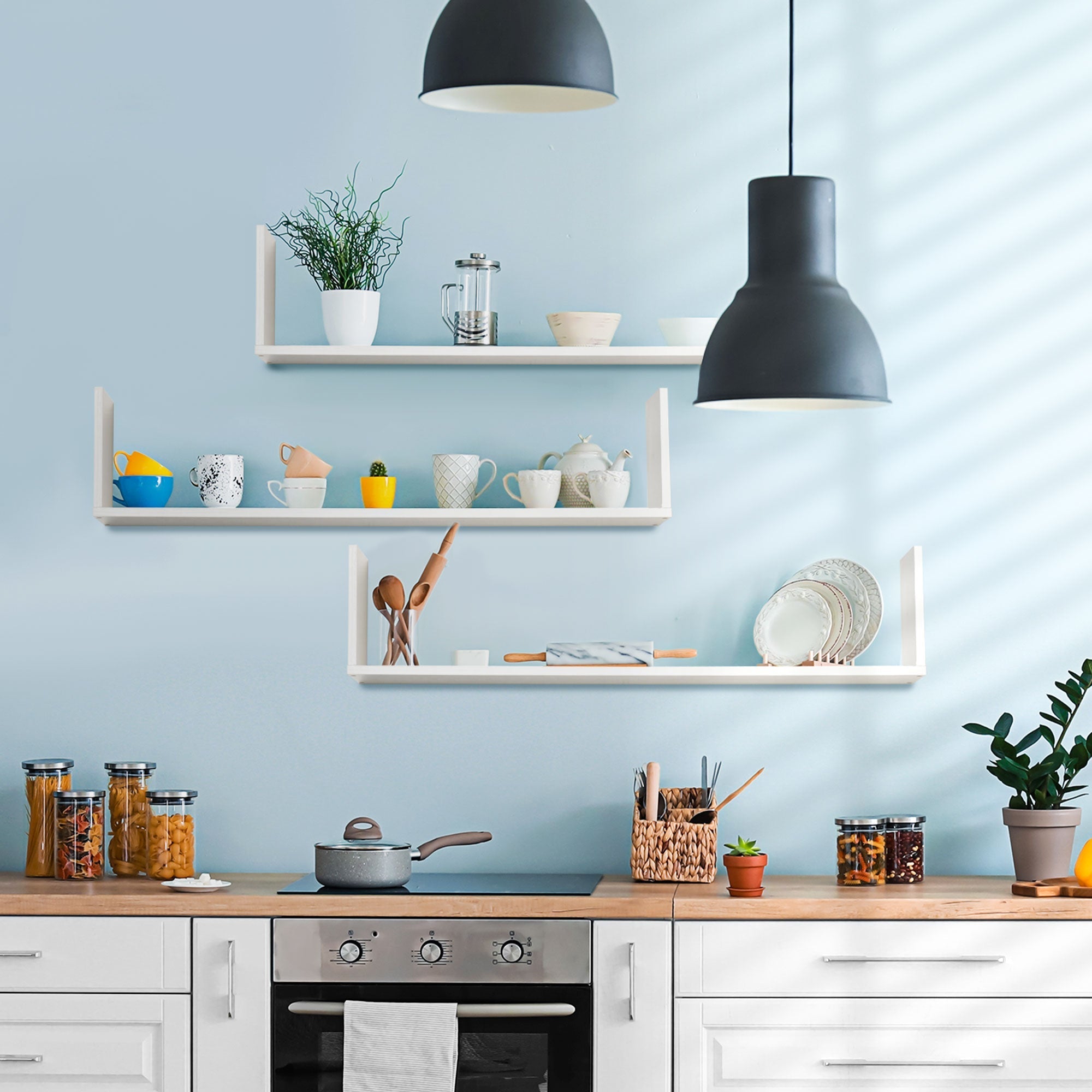 Modern black pendant lights above bright kitchen with white wooden u-shaped floating shelves saving floor space
