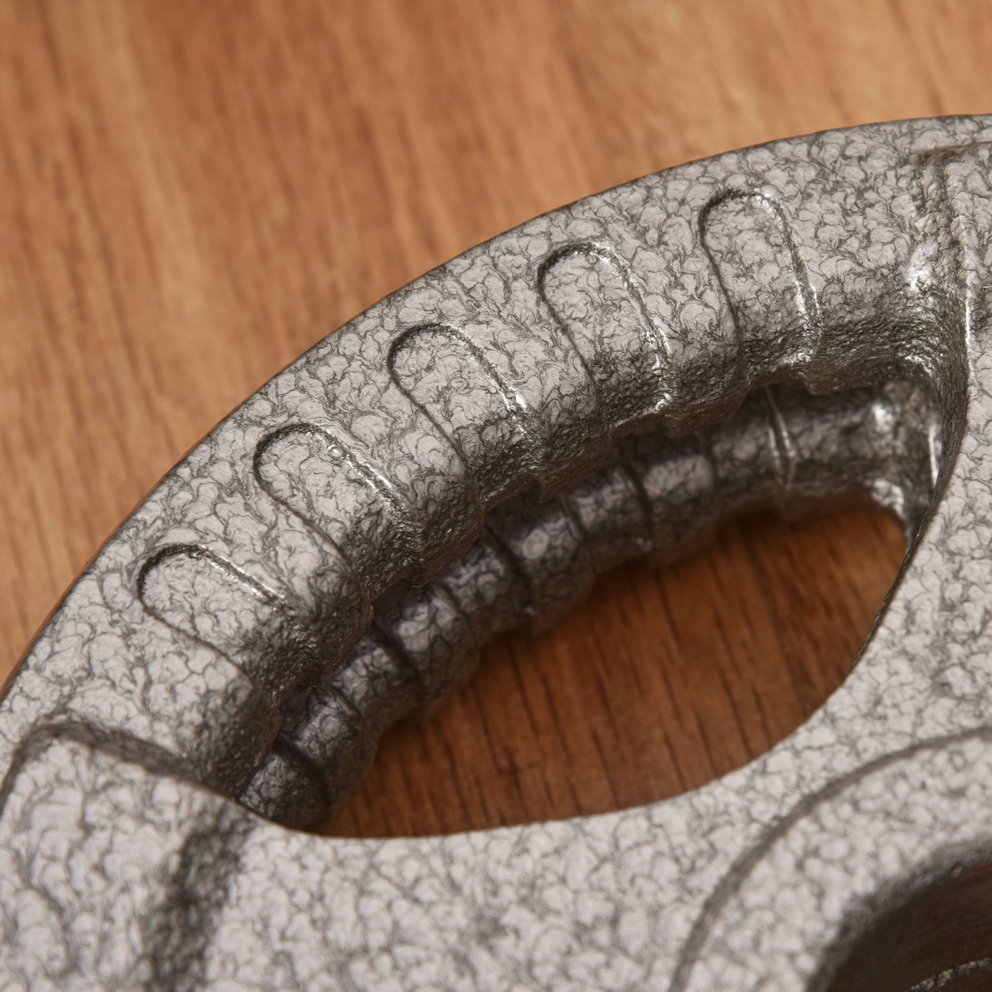 Silver-toned cast iron frying pan with textured crackled finish and ridged hand grip with 5kg plate centre hole