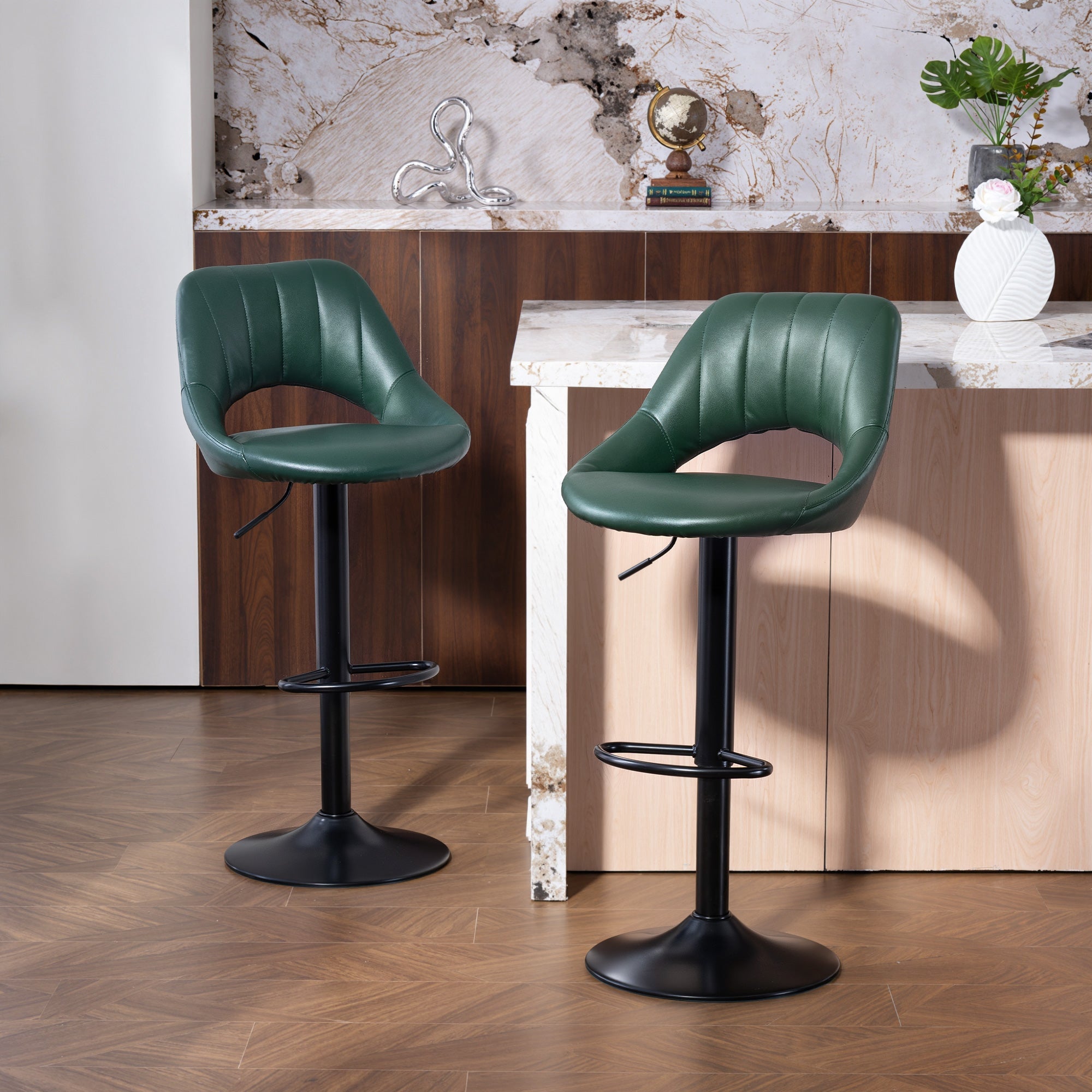 Two dark green faux leather bar stools with black steel frame bases and footrests perfect for home bars