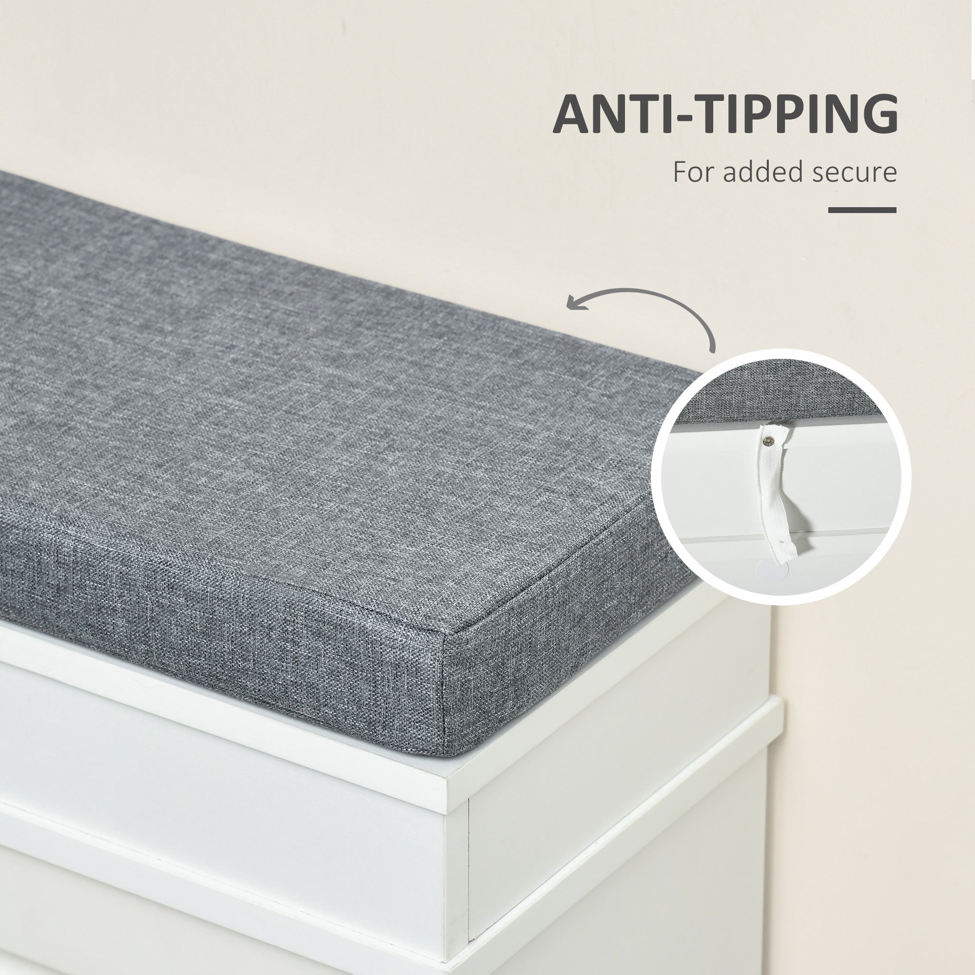 Gray textured fabric cushion with white anti-tip mechanism on white particle board shoe storage bench for entryway seating