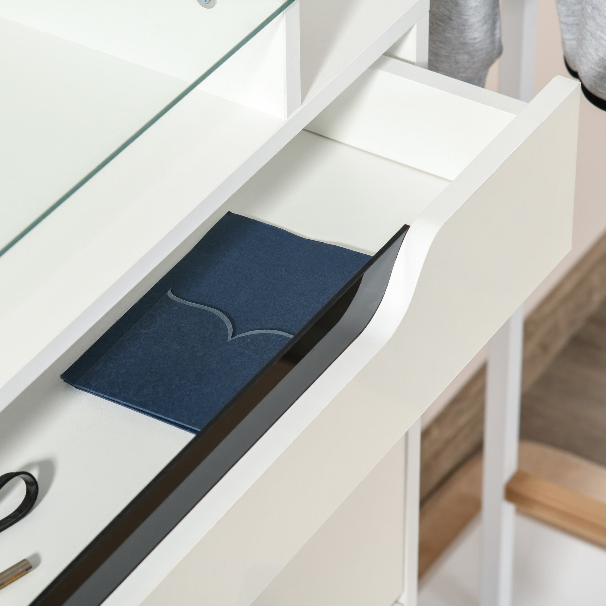 Dark blue leather notebook with silver wave design placed on a homcom shoe cabinet with two flip doors and slide out drawer