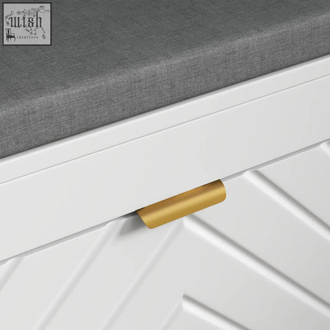 Gold-colored cylindrical drawer pull on white herringbone paneling of homcom shoe storage entryway bench