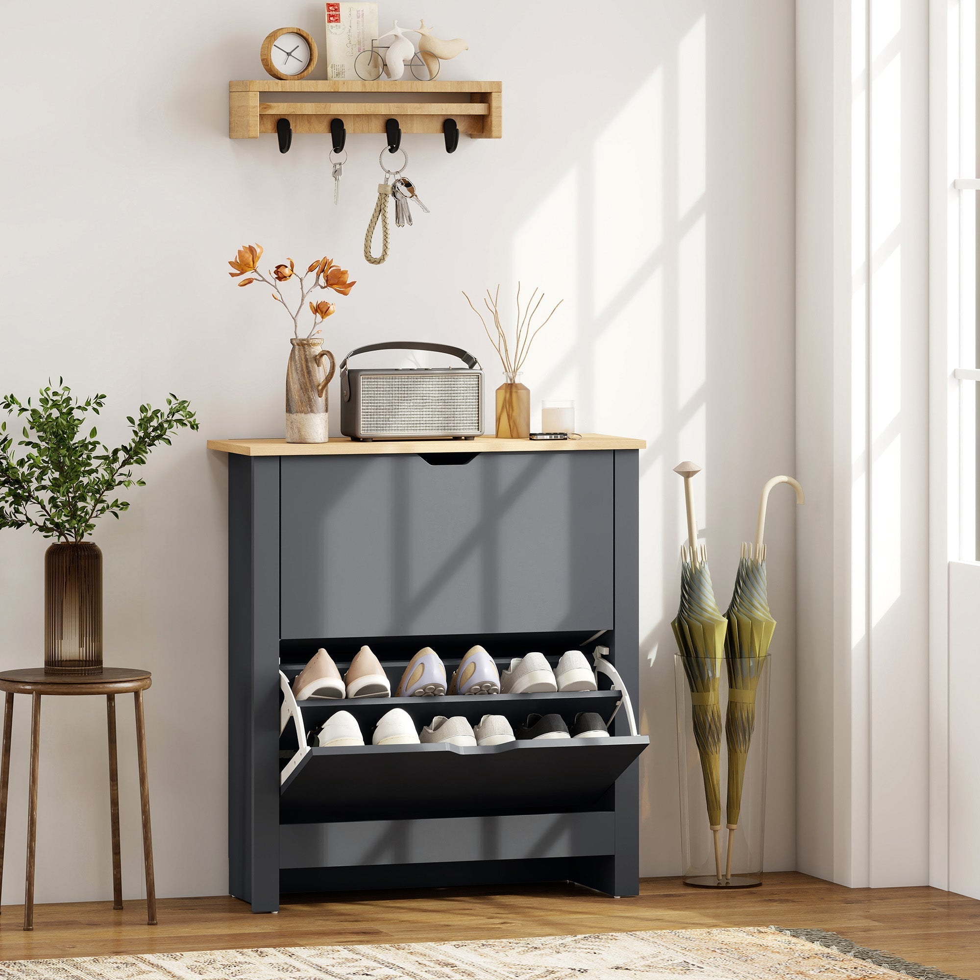 Modern charcoal grey shoe cabinet made of particle board with two pull-out shelves holding white shoes and wooden top