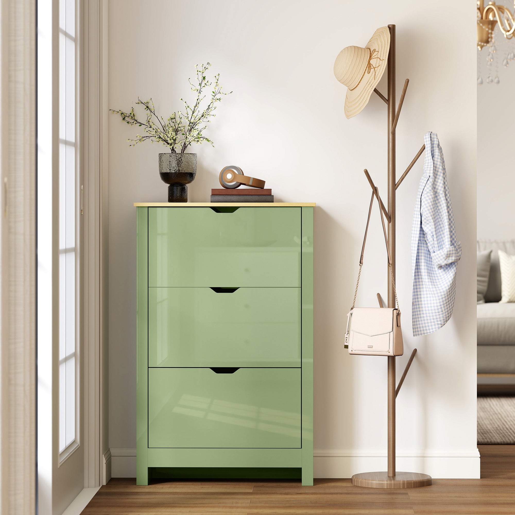 A sleek high gloss green shoe cabinet made of particle board with three flip drawers and minimalist black handles