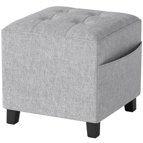 Gray tufted fabric storage ottoman with side pocket and rubber wood legs perfect for living room or bedroom use