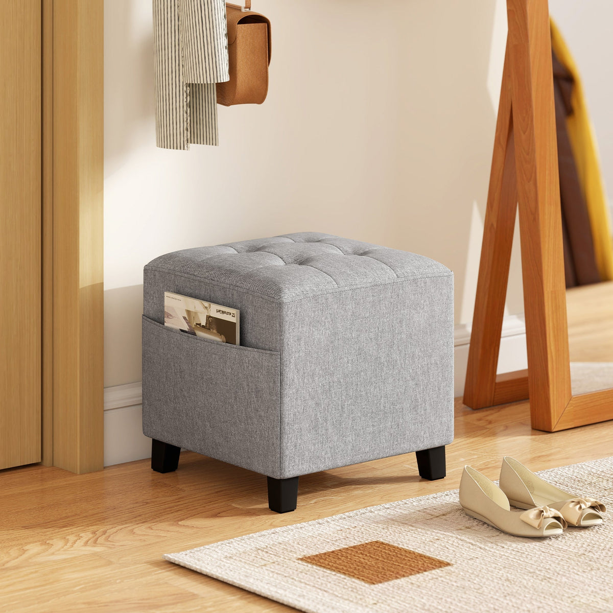 Gray tufted fabric HOMCOM square footstool with wood legs and side pocket holding magazines for living room use