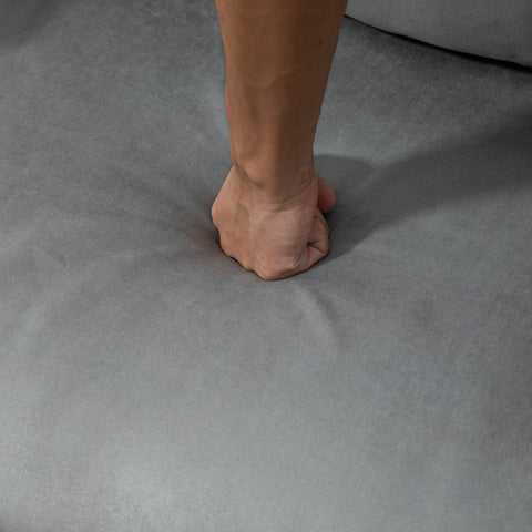 A clenched fist resting on the grey suedette upholstery of the homcom ajustable back futon sofa chair