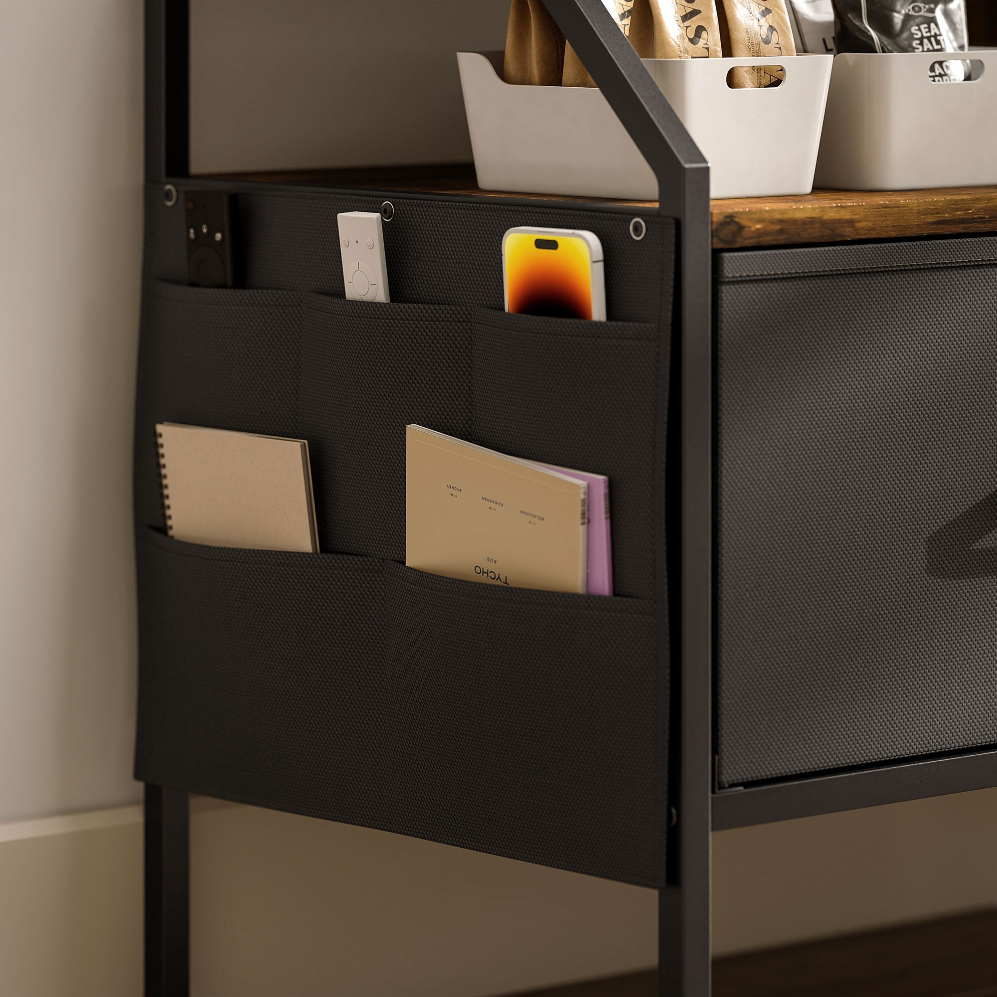 Black mesh organizer with multiple pockets mounted on metal frame inside homcom tv stand cabinet with fabric drawers