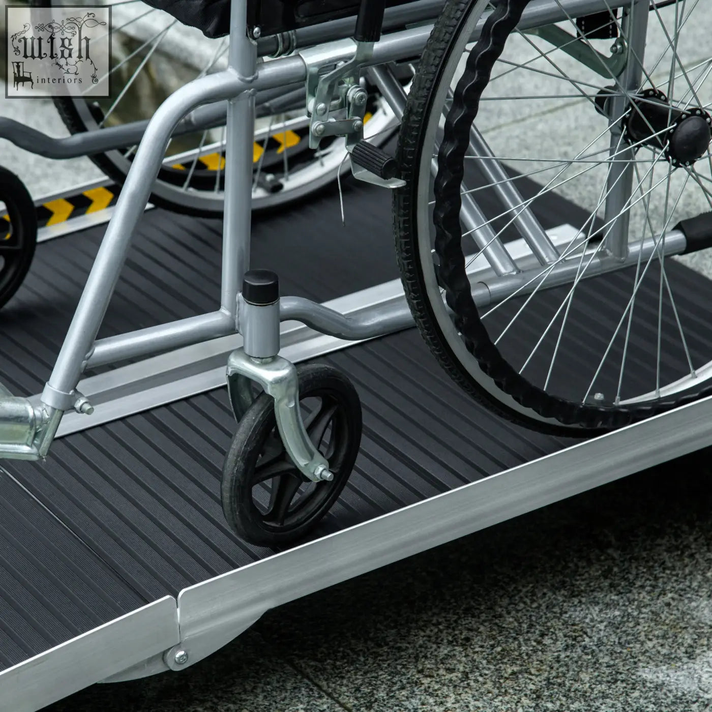Silver aluminium alloy wheelchair ramp with black non skid surface and yellow striped safety edge for threshold use