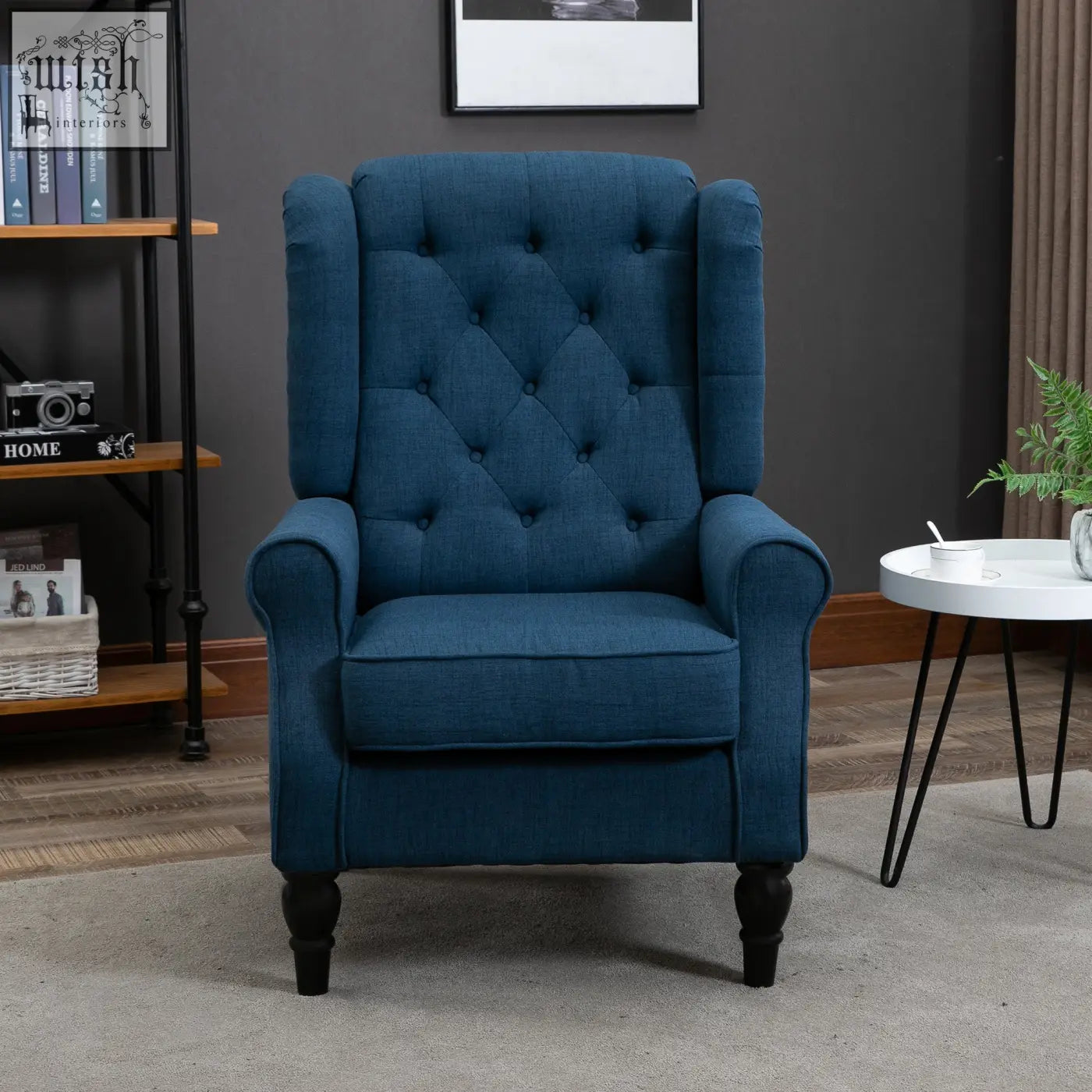 Deep blue tufted wingback accent chair with rolled arms and dark wooden floor height legs for living room or bedroom