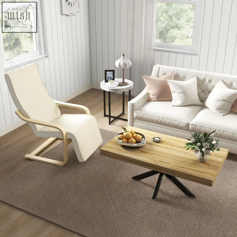 Light wood coffee table with black metal legs and natural wooden top beside cream white birch wood frame lounging chair