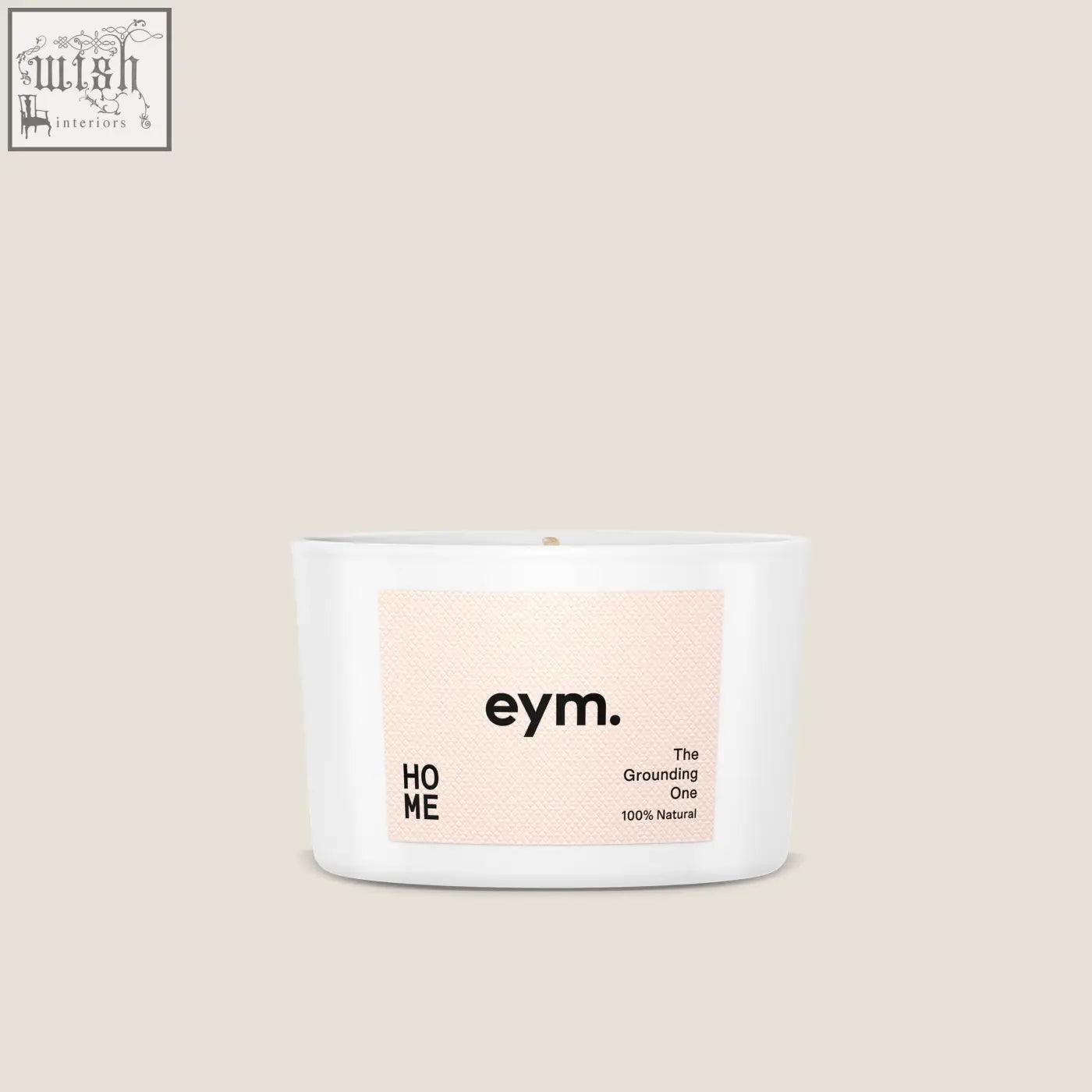 White ceramic mini candle with minimalist eym label the grounding one on soft peach background for home use