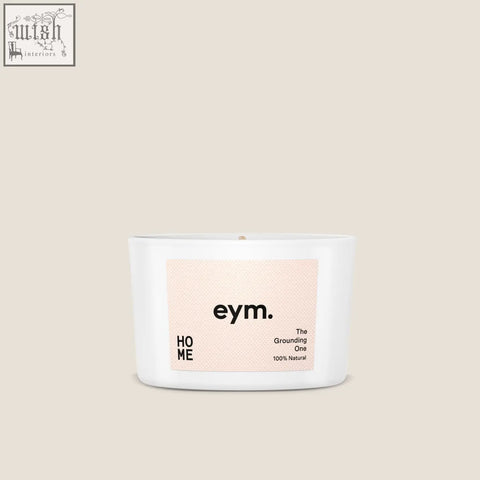 White ceramic mini candle with minimalist eym label the grounding one on soft peach background for home use