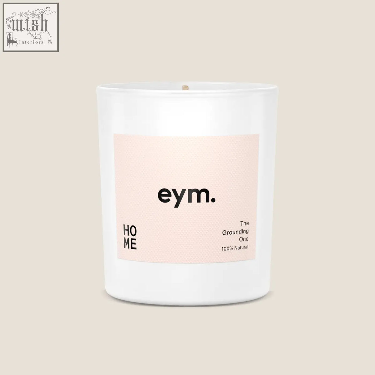 A minimalist white glass standard candle jar with a pale pink eym label called the grounding one 100 percent natural