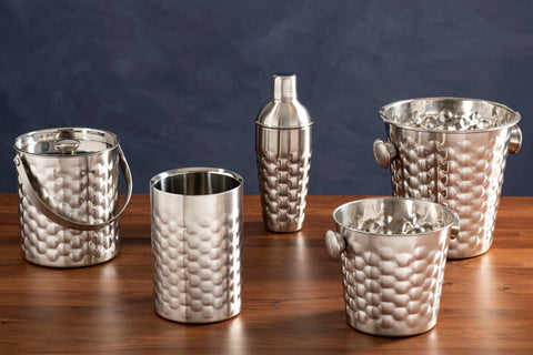 Silver hammered finish cocktail shaker with textured woven pattern and sleek design next to honey bee ice bucket with handles