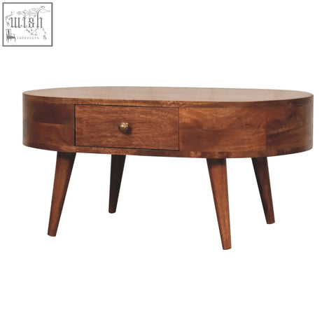 A sleek oval coffee table with honey caramel finish dark wood and tapered legs for stylish living spaces