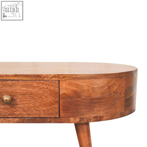 A warm-toned honey caramel coffee table with a smooth rounded wooden top and single drawer with brass knob