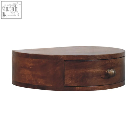 A rustic honey caramel finish rounded bedside table with an oval wooden box drawer and brass knob wall mounted