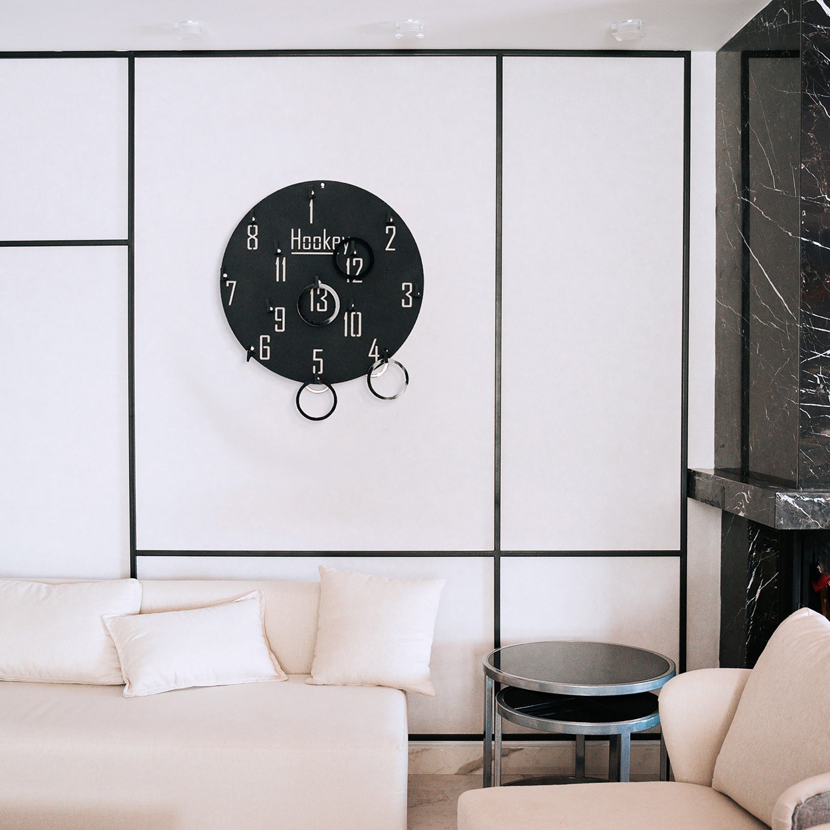 Black circular wall game clock with white numerals and three hanging rings for fun with ages 6 and up