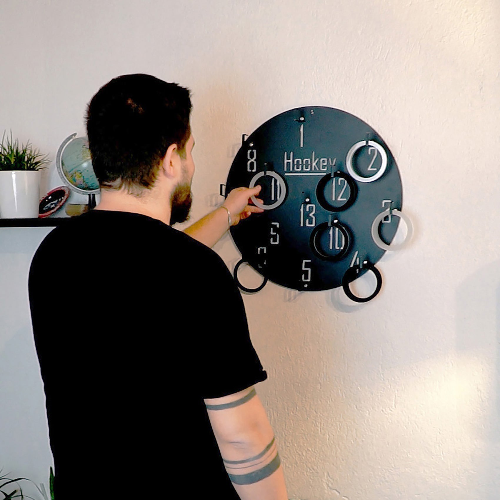 Black circular wall game hookey ring toss with numbered rings and silver accents for all age ranges