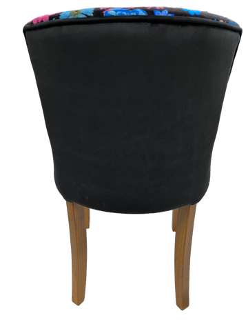 Black upholstered horton chair with wooden legs and colorful floral pattern along the top edge