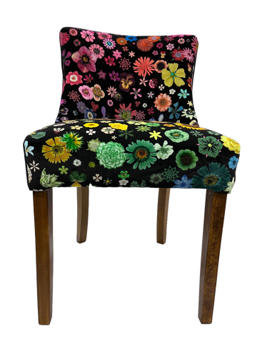 Black velvet horton chair upholstered in vibrant multicolored floral fabric with wooden legs
