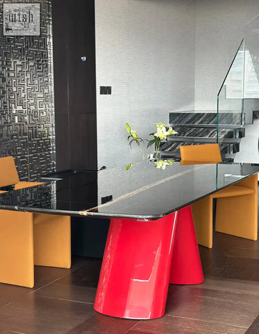 Hossain dining table with a sleek red pedestal and black marble dining glass top for modern dining spaces