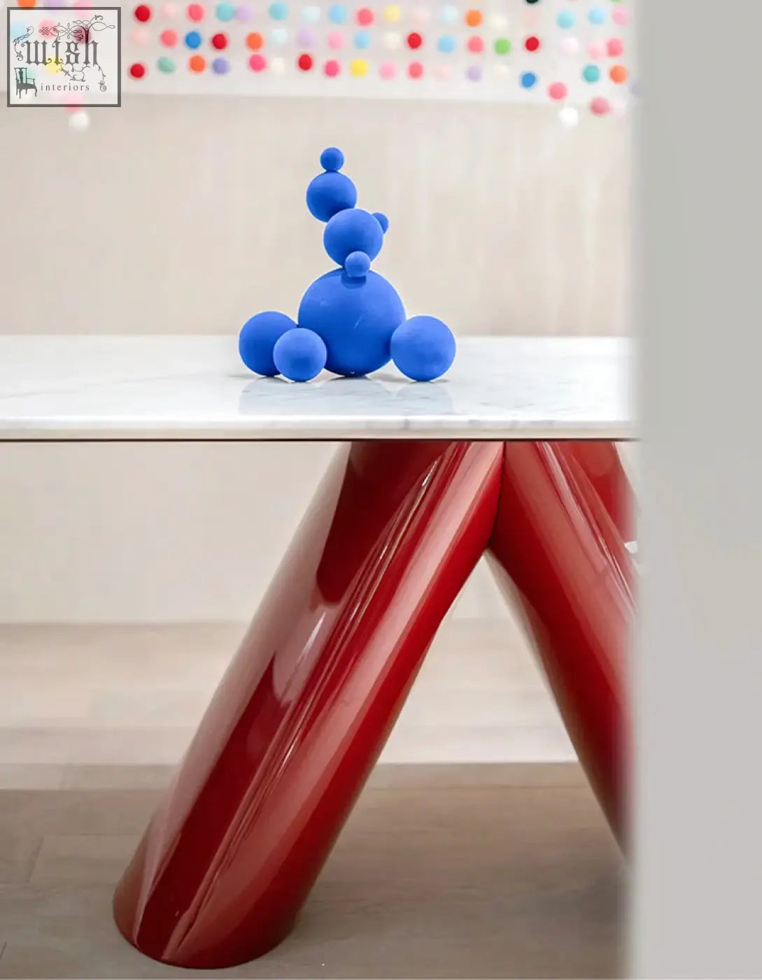 A vibrant blue sculpture on a marble dining table adding a playful touch to the hossain dining table setup